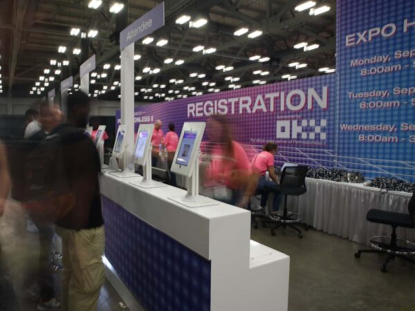 blurred image of people moving at a trade show registration desk